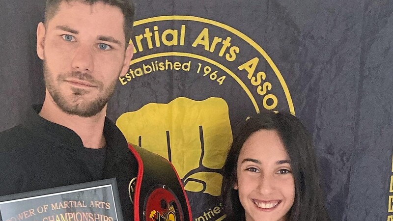 Die zehnjährige Aylin Mubarritz (r.) und Manuel Loichinger, Übungs- und Abteilungsleiter Kung Fu beim SSC Landau, präsentierten stolz ihre Urkunden und Gürtel.