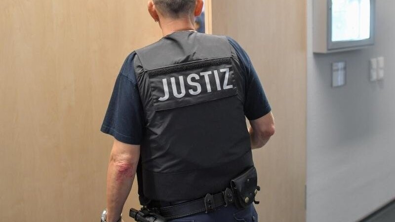 Ein Justizmitarbeiter schließt die Tür zu einem Verhandlungssaal.