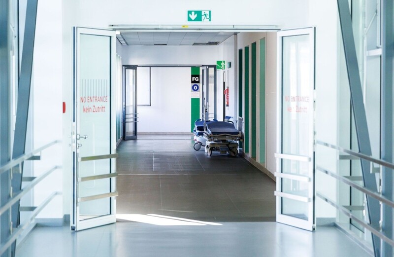 Krankenbetten stehen in einem Gang in einem Krankenhaus. 