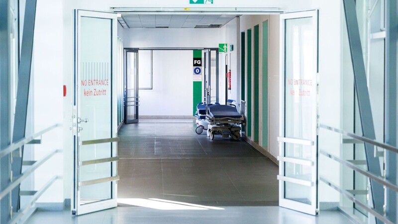 Krankenbetten stehen in einem Gang in einem Krankenhaus.