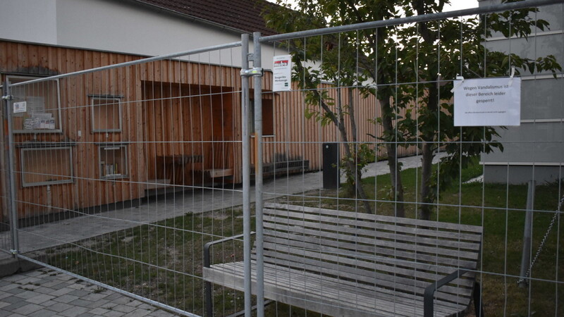 Ein Bauzaun versperrt die bislang hochgelobte Leseecke auf dem Kirchplatz, weil Randalierer ihr Zerstörungswerk allabendlich hinterlassen.