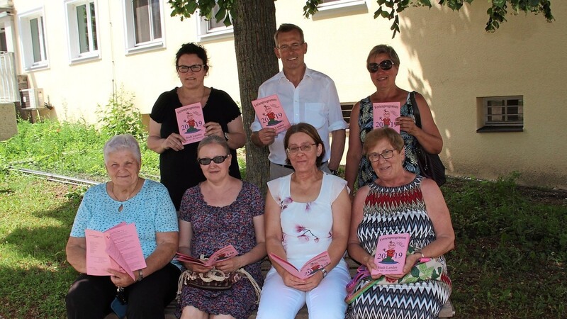 Theresia Wunderlich (sitzend, v.l.), Ljuba Wirth, Monika Troiber, Therese Retzer, Andrea Maier (stehend, v.l.), Bürgermeister Helmut Steininger und Christine Fronhofer bei der Vorstellung des Ferienprogramms.