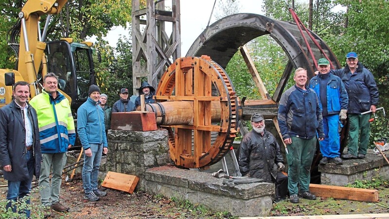 Mitarbeiter des Wasserwirtschaftsamtes Regensburg setzen die neue Welle für das Wasserrad ein; links im Bild Bürgermeister Markus Hofmann, Josef Stelzl von der Flussmeisterei Roding und Helmut Holzer, Sachgebietsleiter Wasserbau für den Landkreis Cham.