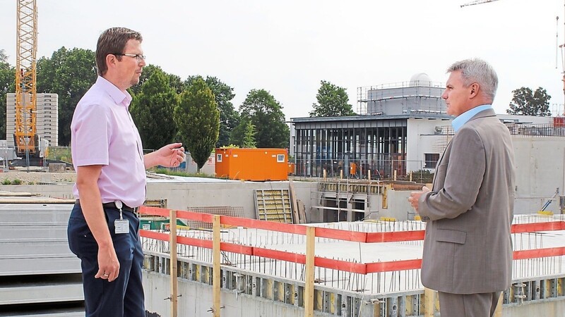 Landrat Peter Dreier (r.) informierte sich bei Thomas Stöckl, Leiter des kreiseigenen Hochbaus, über den Fortschritt der aktuell laufenden Baumaßnahmen des Landkreises: Aus der Baustelle in der Nachbarschaft des Gymnasiums Vilsbiburg ist mittlerweile eine stattliche Turnhalle geworden.