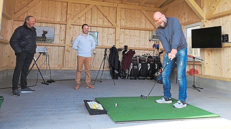 Graham und Darren Hillier, beide Fully Qualified Golf Professionals (PGA), beobachten Clubpräsident Jim Gebhardt beim Abschlag aus der neuen Hütte mit Videoanalyse. Dafür hat man insgesamt über 50 000 Euro investiert.