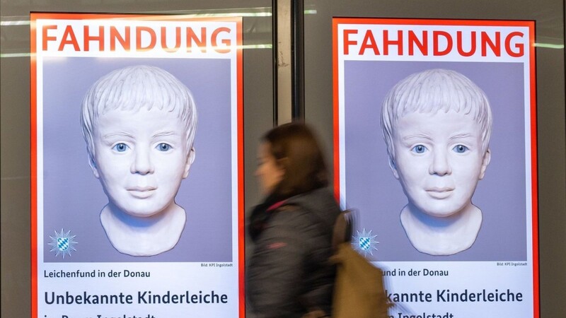 Eine Frau geht am Ostbahnhof in München an einem digitalen Fahndungsplakat vorbei.